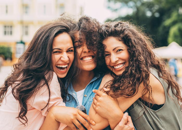 group of 3 female friends smiling